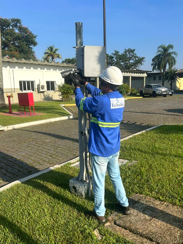 Técnico instalando câmera CFTV externa